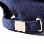 Detailansicht des größenverstellbaren Verschlusses der dunkelblauen GRAHAM HILL Cap mit Metallspange und graviertem Logo.