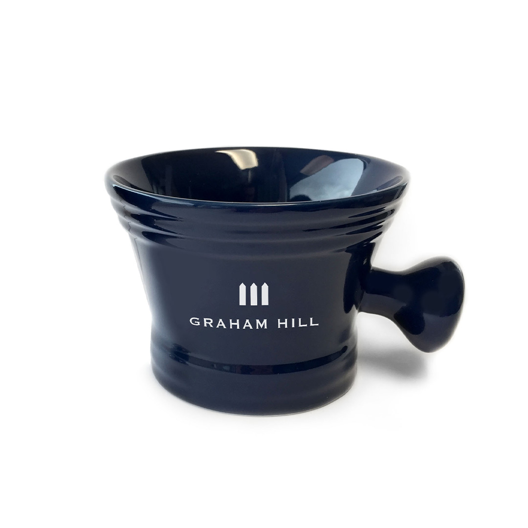 Dunkelblaue GRAHAM HILL SHAVING BOWL aus Porzellan mit seitlichem Griff und weissem Markenlogo.